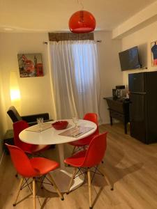 una mesa blanca con sillas rojas en la sala de estar. en Casa Nova Luxury Apartment Suite Limoni, en Nova Milanese