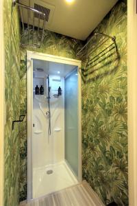 y baño con ducha y papel pintado verde. en Sumida-ku - House / Vacation STAY 80877, en Tokio