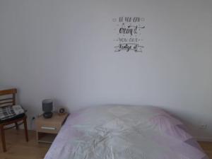 een slaapkamer met een bed en een bord aan de muur bij En passant par La Maraude in Vigneulles-lès-Hattonchâtel
