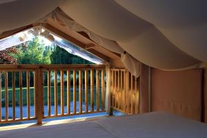 a view of a porch with a bed and a balcony at Glamping Resort Rio Vantone in Crone +182 photos