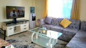 a living room with a couch and a tv at Inviting 1-Bed Cozy Apartment in Mombasa in Mombasa +7 photos