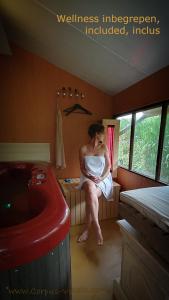 Una donna seduta su un divano in una stanza di B&B CountryHeART a Sint-Laureins