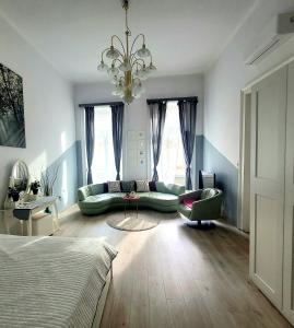 ブダペストにあるNóra Holiday Apartmentのソファとシャンデリア付きの広いリビングルーム
