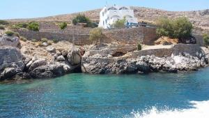 a body of water with a building in the background at Kazonis Studios in Kalymnos