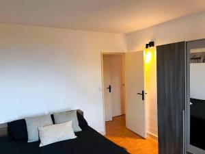 a bedroom with a bed and a door to a hallway at À 5 min de Paris , appartement calme,au pied du métro et très bien équipé in Maisons-Alfort