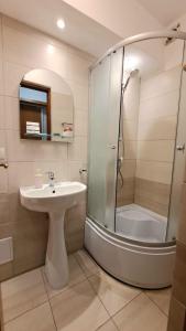 een badkamer met een wastafel en een douche bij Închiriez garsoniera în regim hotelier unirii in Boekarest