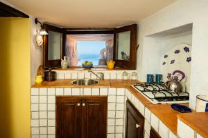 eine Küche mit Spüle, Herd und Fenster in der Unterkunft Marulivo Hotel in Pisciotta