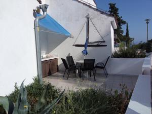 a patio with a table and chairs and an umbrella at Apartment Tara in Nečujam