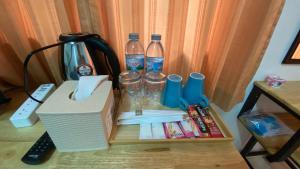 una mesa con 2 botellas de agua y bebidas en ธนทรัพย์อพาร์ทเม้นท์ Room01, en Pathum Thani