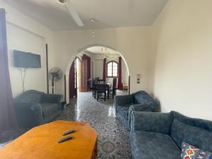 Sala de estar con 2 sofás y mesa en Gîte Hôtel Gezira Louxor, en Luxor