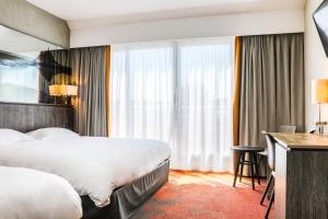 a hotel room with a bed and a desk at Hotel De La Digue in Le Mont Saint Michel