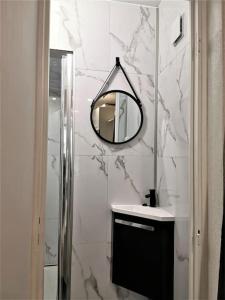 ein Badezimmer mit einem Spiegel und einem Waschbecken in der Unterkunft Charmant Studio idéalement situé in Morez