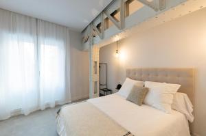 a bedroom with a large bed with white pillows at Diana Suites 23 in Málaga