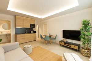 sala de estar con sofá, TV y mesa en Diana Suites 23, en Málaga