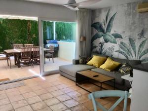 ein Wohnzimmer mit einem Sofa und einem Tisch in der Unterkunft Casa de 2 dormitorios con piscina, 2 terrazas privadas, WIFI, BBQ in Denia