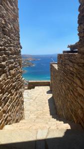 a stone alley with the ocean in the background at andros prive suites in Kipri