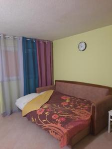 ein Schlafzimmer mit einem Bett und einer Uhr an der Wand in der Unterkunft Apartman Nikšić centar in Nikšić