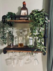 un estante con gafas, un reloj y una planta en Mr. McGregor’s Garden en Salem