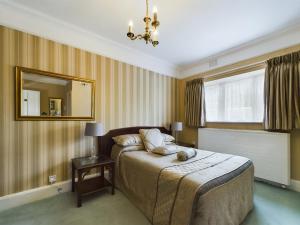 1 dormitorio con cama y espejo. en Beech House Hotel en Reading
