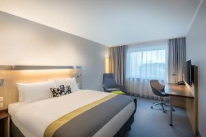 a hotel room with a bed and a desk at Holiday Inn Express Gütersloh by IHG in Gütersloh