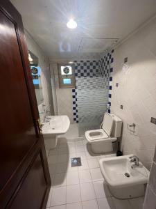 a bathroom with a toilet and a sink at Hotel Leaders Plaza Mahboula in Kuwait