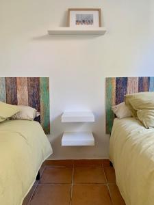 ein Schlafzimmer mit 2 Betten und einem Regal an der Wand in der Unterkunft Casa de 2 dormitorios con piscina, 2 terrazas privadas, WIFI, BBQ in Denia
