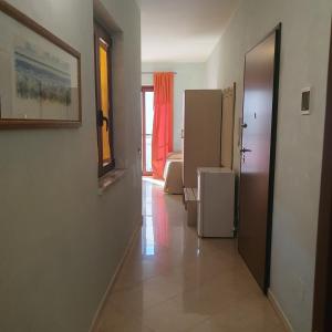 Cette chambre dispose d'un couloir et d'un réfrigérateur. dans l'établissement Hotel Ristorante Rinelli, à Margherita di Savoia