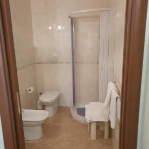 La petite salle de bains est pourvue d'une douche et de toilettes. dans l'établissement Hotel Ristorante Rinelli, à Margherita di Savoia
