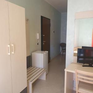 Cette chambre comprend un banc, un réfrigérateur et un bureau. dans l'établissement Hotel Ristorante Rinelli, à Margherita di Savoia