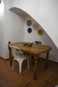 a wooden table and a chair in a room at Casa de pueblo Ca Barret, a tan sólo dos kilómetros de Xàtiva 