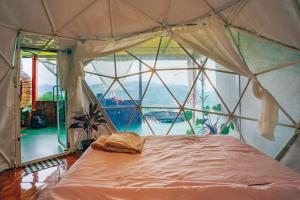 um quarto com uma cama numa tenda com uma janela em ไร่ดอยช้าง ม่อนเเจ่ม em Mon Jam