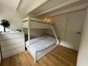 Ce lit superposé blanc se trouve dans un dortoir doté d'une commode. dans l'établissement Boshuis met erg veel luxe, à Rheezerveen