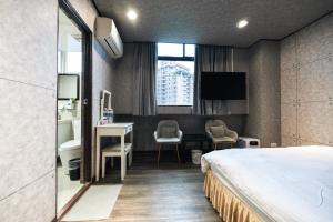 una camera d'albergo con un letto e una scrivania di Sofu Hotel a Taipei