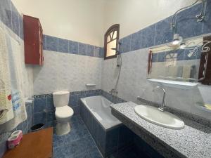 a bathroom with a sink and a toilet and a tub at Gîte Hôtel Gezira Louxor in Luxor