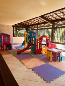 ein Zimmer mit einem Spielplatz mit einem Tisch und Spielgeräten in der Unterkunft Praia do Forte - ap Bali Bahia 107 in Praia do Forte