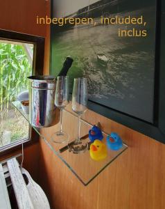 un tavolo di vetro con due bicchieri e due anatre di gomma di B&B CountryHeART a Sint-Laureins