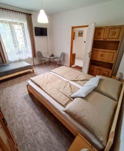 ein Schlafzimmer mit einem großen Bett und ein Wohnzimmer in der Unterkunft Park Nyaralóház in Badacsonytomaj
