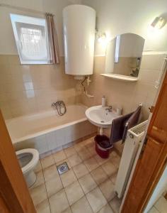 a bathroom with a sink and a tub and a toilet at Park Nyaralóház in Badacsonytomaj