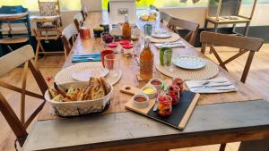 a long wooden table with food on it at Le Bois aux Cerfs in Bois-Jérôme-Saint-Ouen