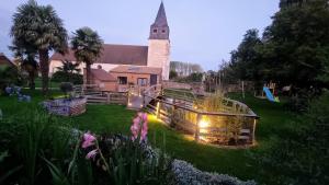 a church with a clock tower in a yard at Le Bois aux Cerfs in Bois-Jérôme-Saint-Ouen