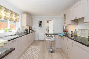 a kitchen with white cabinets and a black counter top at Enchanting Haven in Todmorden