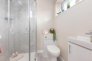 uma casa de banho com um chuveiro, um WC e um lavatório. em Enchanting Haven em Todmorden