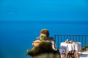 una terraza con una mesa con un cactus. en Marulivo Hotel, en Pisciotta