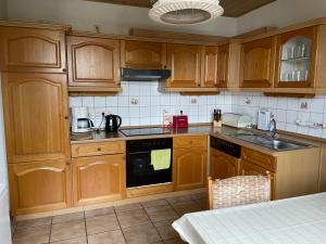 - une cuisine avec des placards en bois et un évier dans l'établissement Panoramavilla Heidenau, à Heidenau