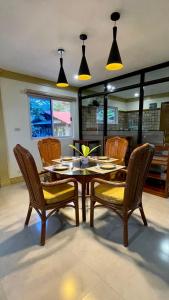a dining room with a table and chairs and lights at Beautiful 2BD Farmhouse for 6pax in Ormoc