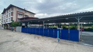 a blue gate in front of a building at ธนทรัพย์อพาร์ทเม้นท์ Room02 in Pathum Thani
