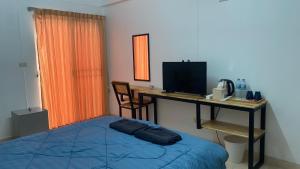 Schlafzimmer mit einem Bett und einem Schreibtisch mit einem Computer in der Unterkunft ธนทรัพย์อพาร์ทเม้นท์ Room02 in Pathum Thani