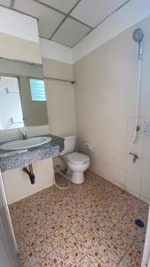 La salle de bains est pourvue de toilettes, d'un lavabo et d'un miroir. dans l'établissement ธนทรัพย์อพาร์ทเม้นท์ Room02, à Pathum Thani