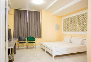 a bedroom with a bed and a desk and chairs at Domus Hotel in Aktau