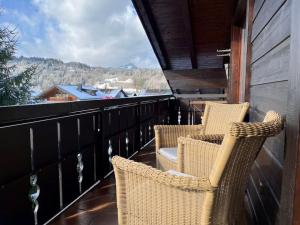 a balcony with two chairs and a view of the mountains at Ferienwohnung Erika in Oberstdorf